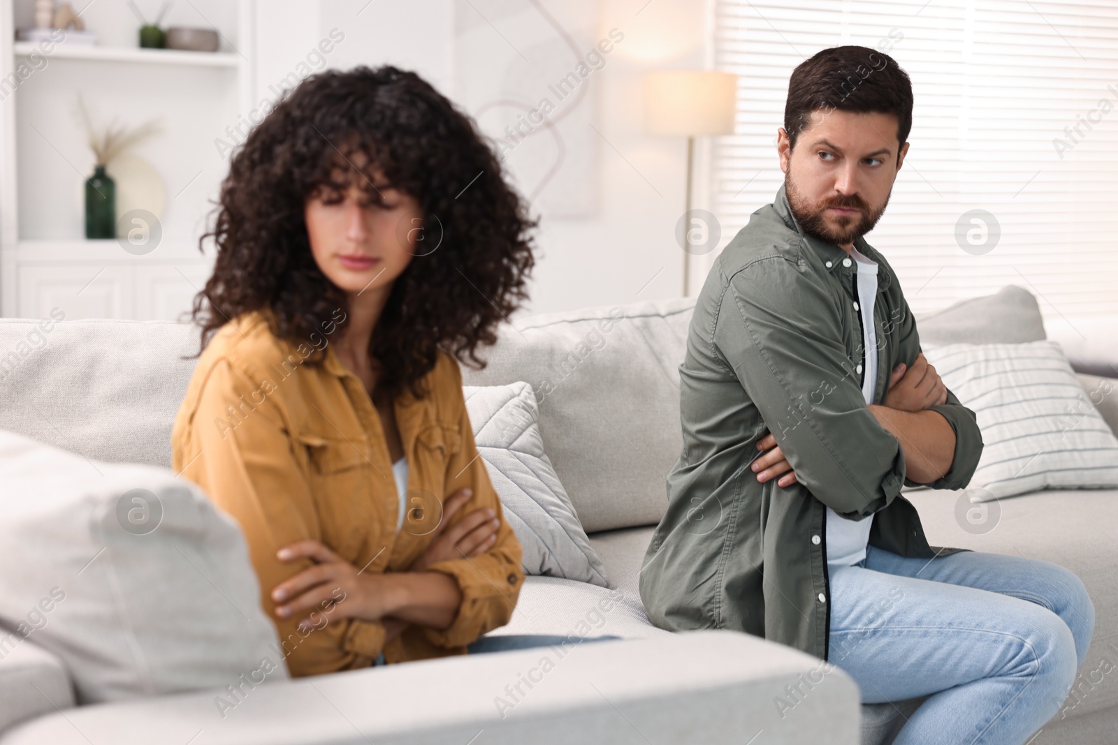 Photo of Couple having quarrel on sofa at home, selective focus. Relationship problems