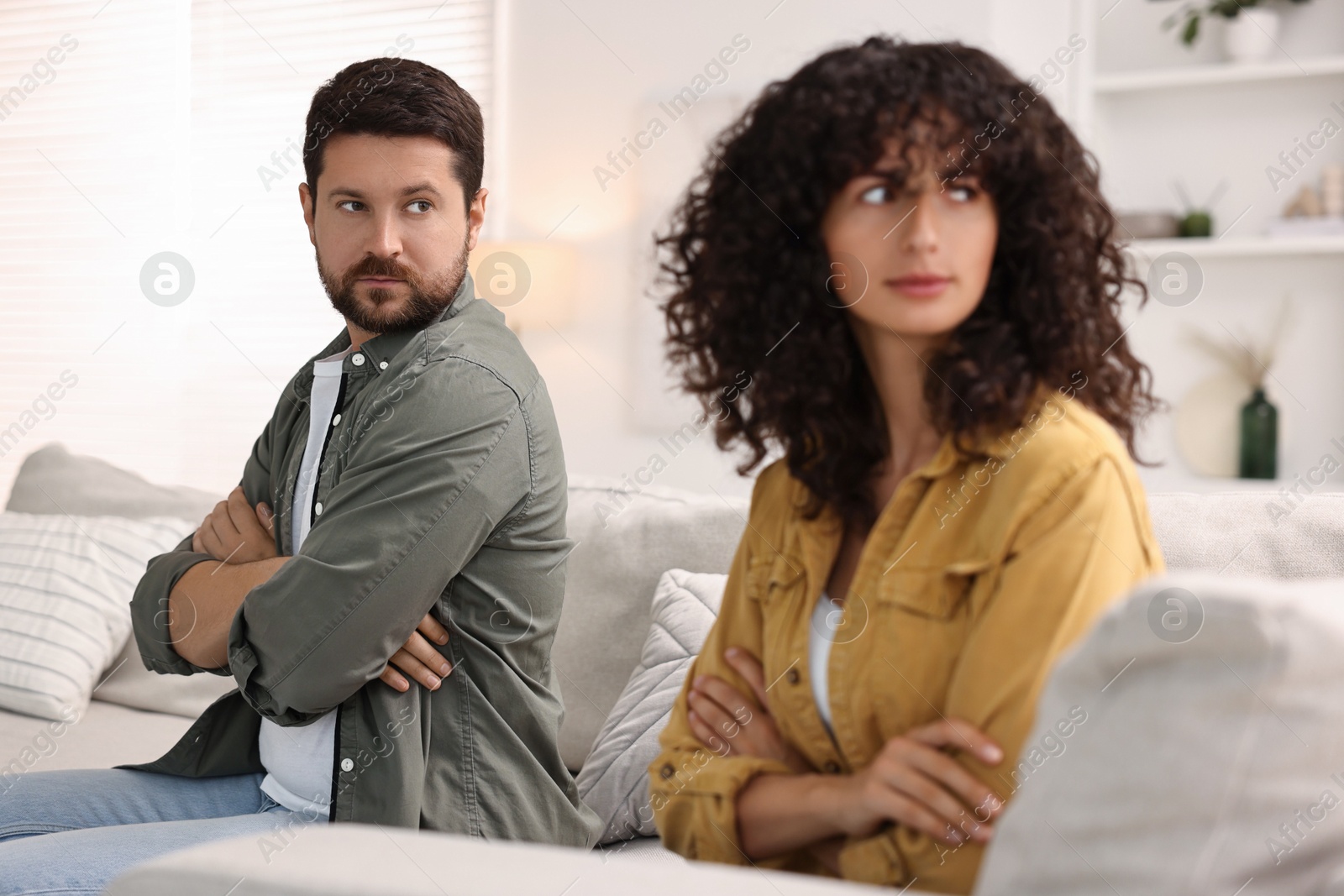 Photo of Couple having quarrel on sofa at home, selective focus. Relationship problems