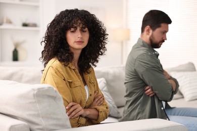 Photo of Couple having quarrel on sofa at home, selective focus. Relationship problems