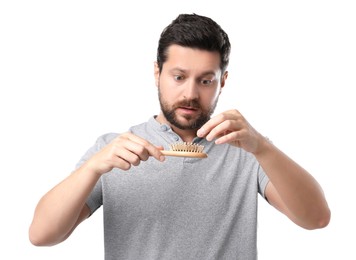 Sad man taking his lost hair from brush on white background. Alopecia problem