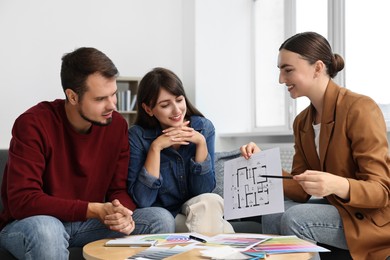 Designer discussing project with clients at table in office