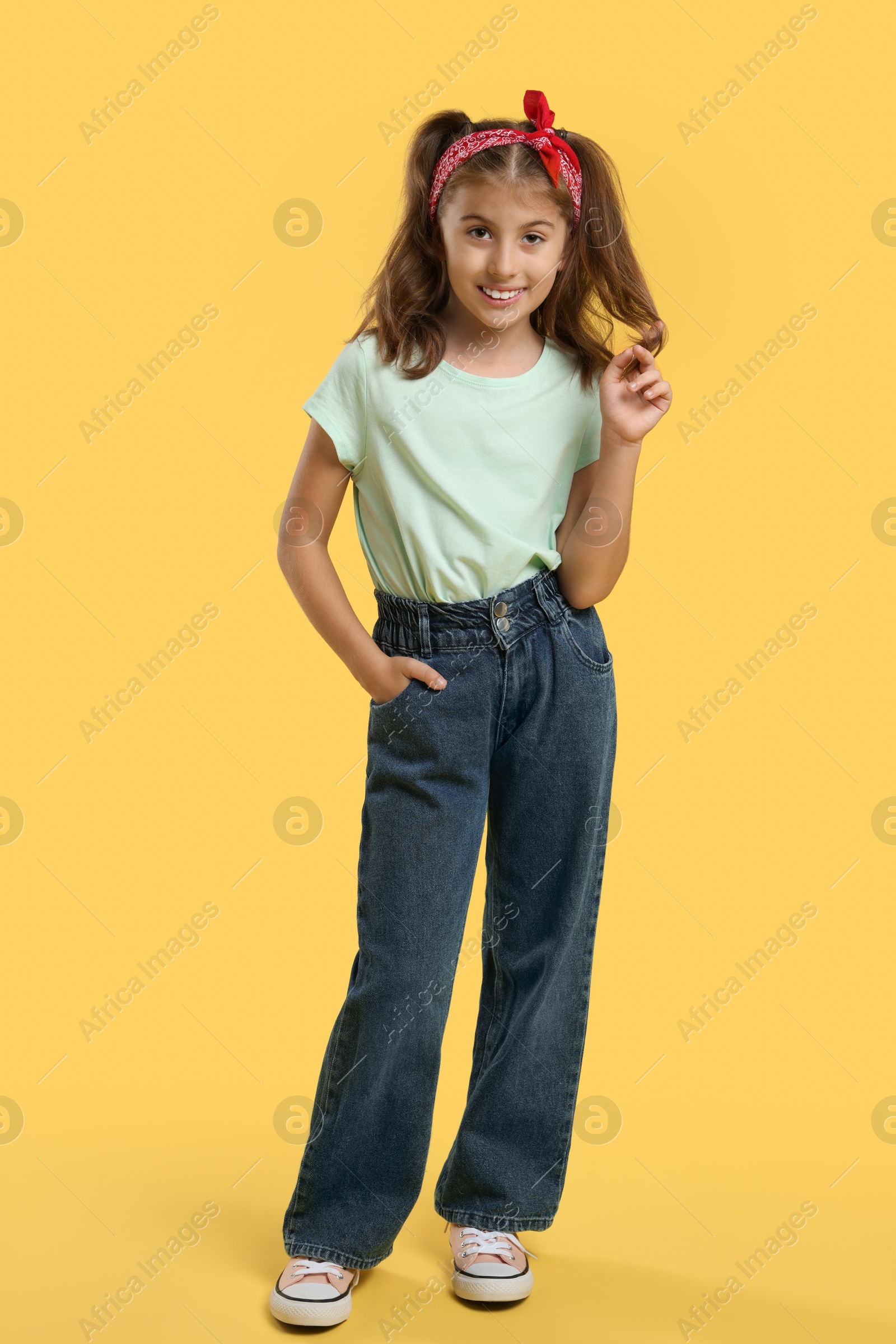 Photo of Full length portrait of cute girl on yellow background