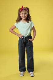 Photo of Full length portrait of cute girl on yellow background