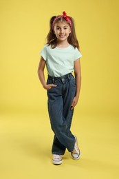 Photo of Full length portrait of cute girl on yellow background