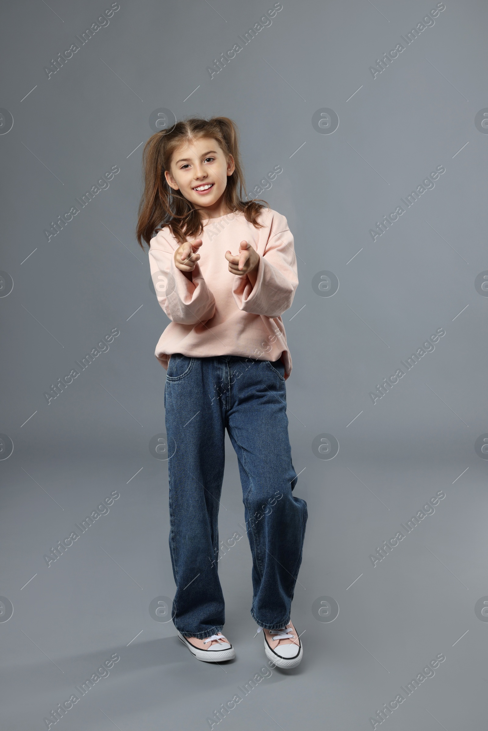 Photo of Full length portrait of cute girl on grey background