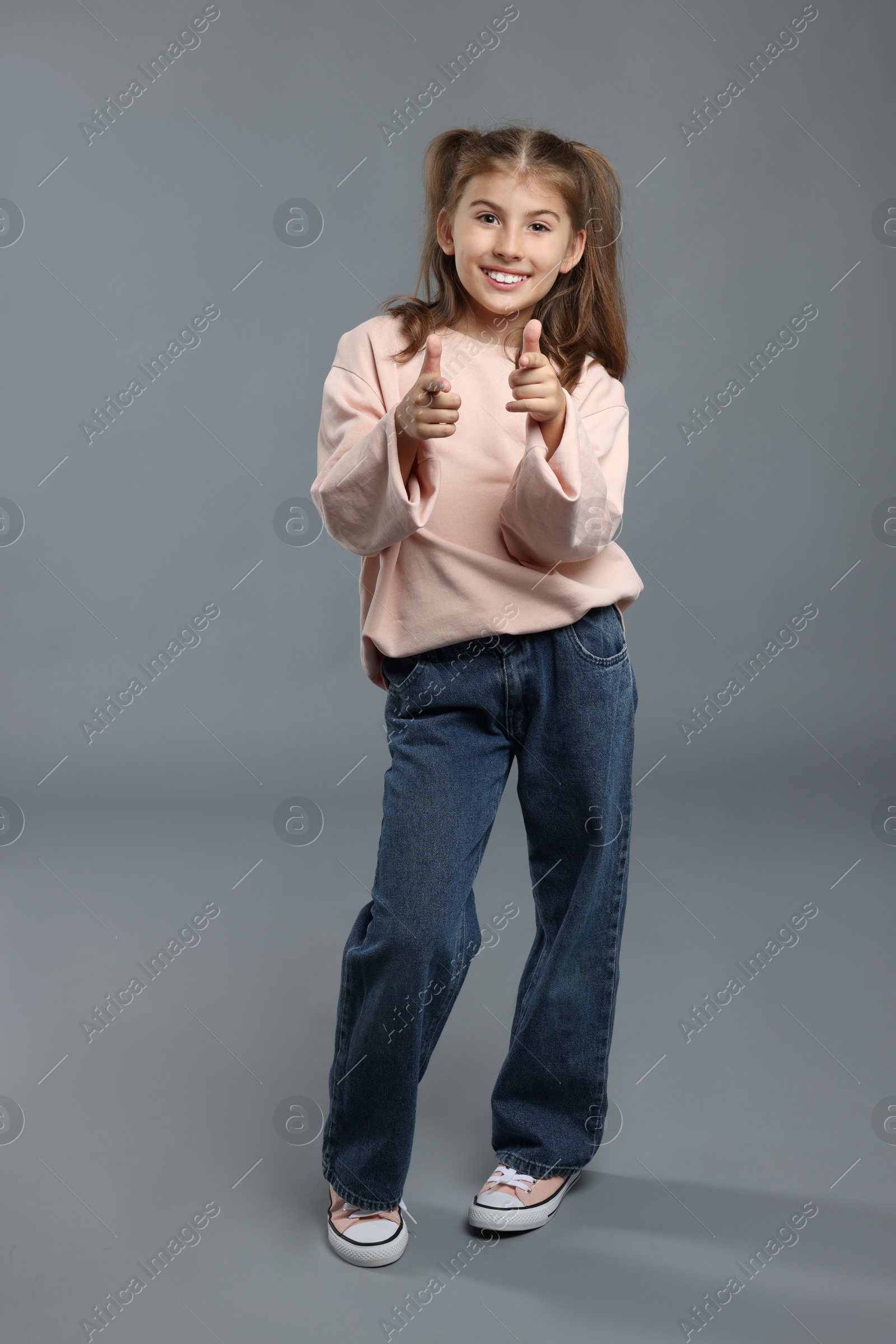 Photo of Full length portrait of cute girl on grey background