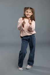 Photo of Full length portrait of cute girl on grey background