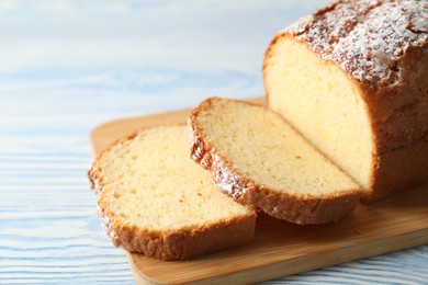 Photo of Freshly baked sponge cake on light blue wooden table, closeup