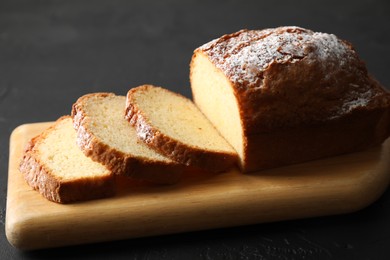 Photo of Freshly baked sponge cake on black table, closeup