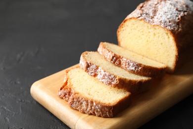 Photo of Freshly baked sponge cake on black table, closeup