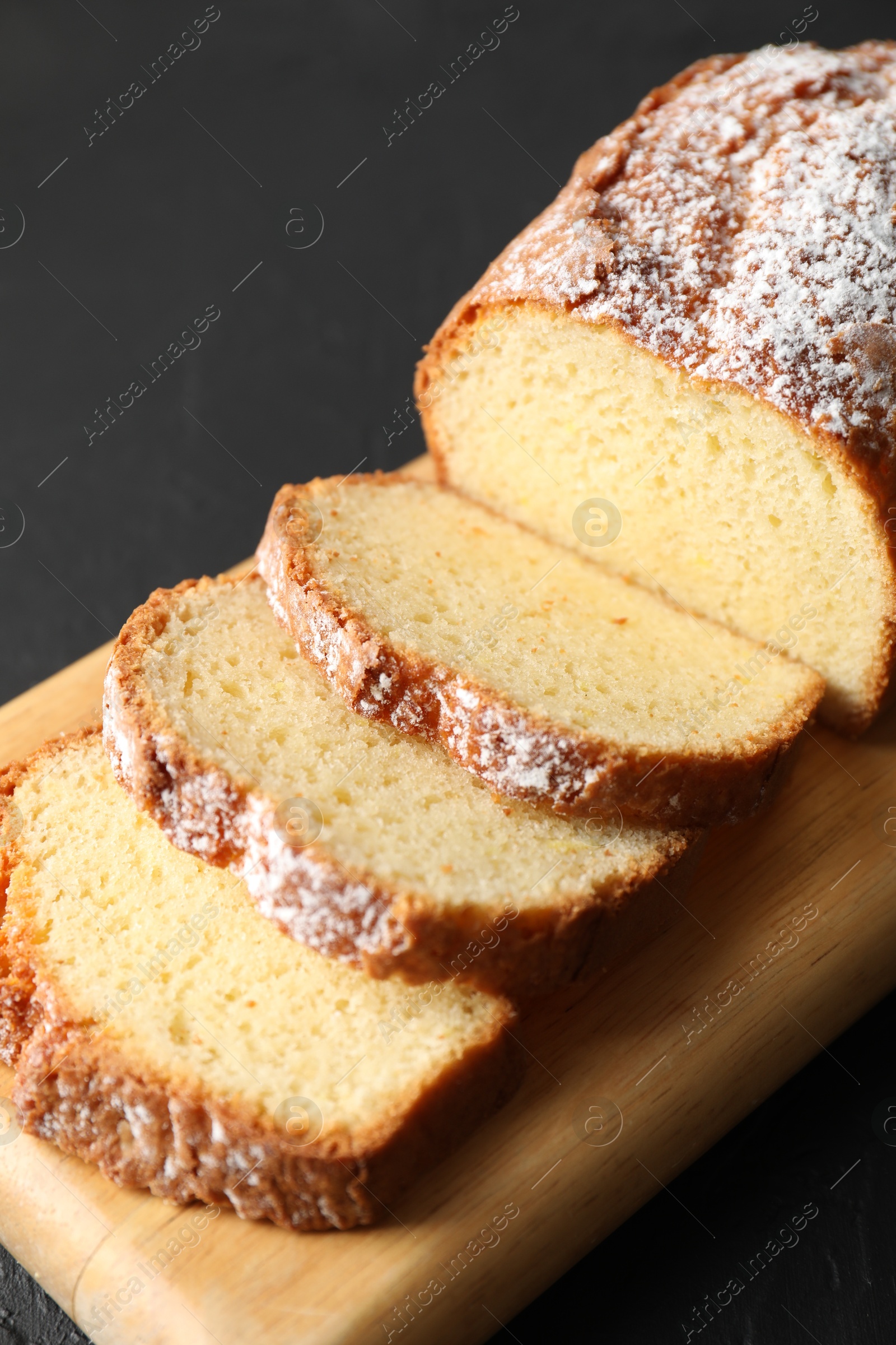 Photo of Freshly baked sponge cake on black table, closeup