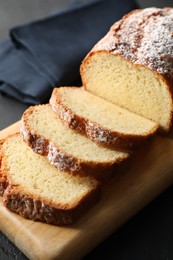 Photo of Freshly baked sponge cake on black table, closeup