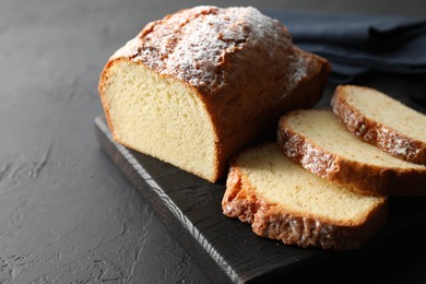 Photo of Freshly baked sponge cake on black table, closeup