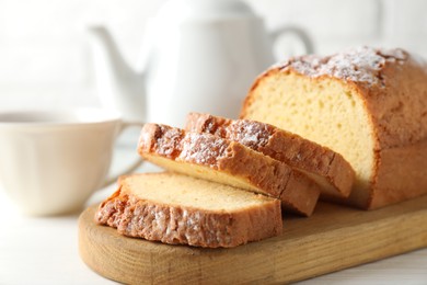 Photo of Freshly baked sponge cake on white wooden table, closeup