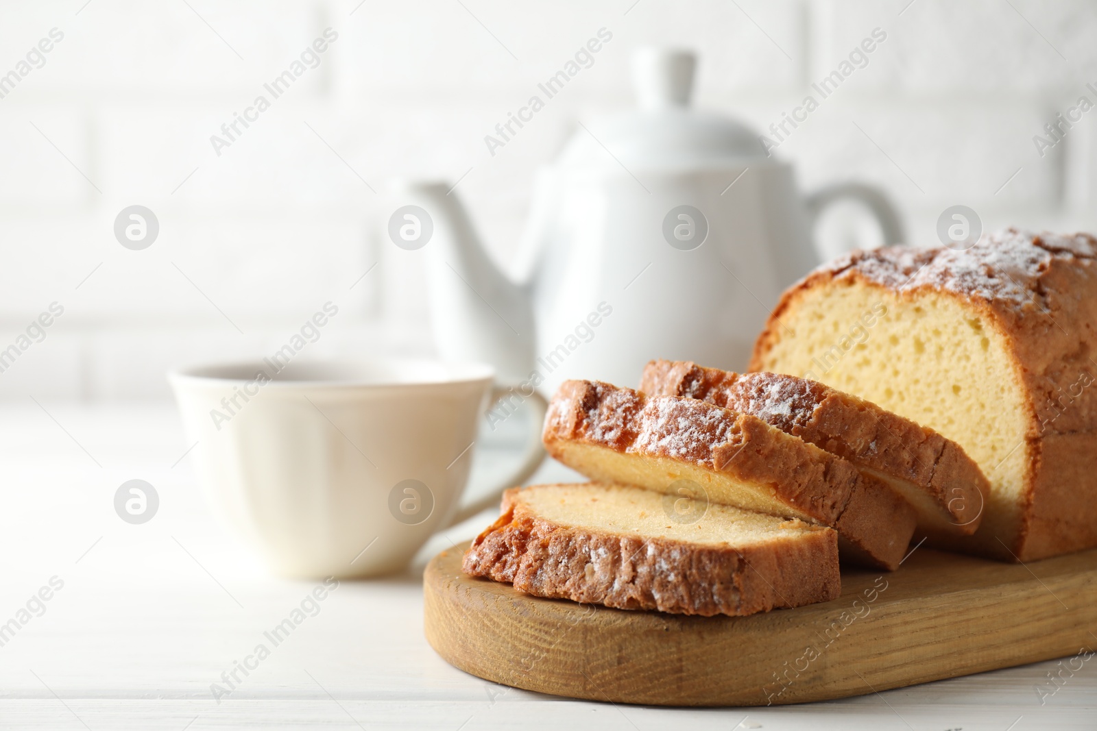 Photo of Freshly baked sponge cake on white wooden table, closeup. Space for text