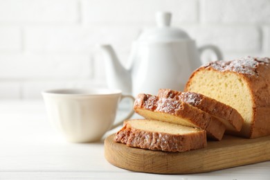 Photo of Freshly baked sponge cake on white wooden table, closeup. Space for text