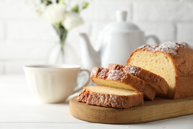 Photo of Freshly baked sponge cake on white wooden table, closeup. Space for text