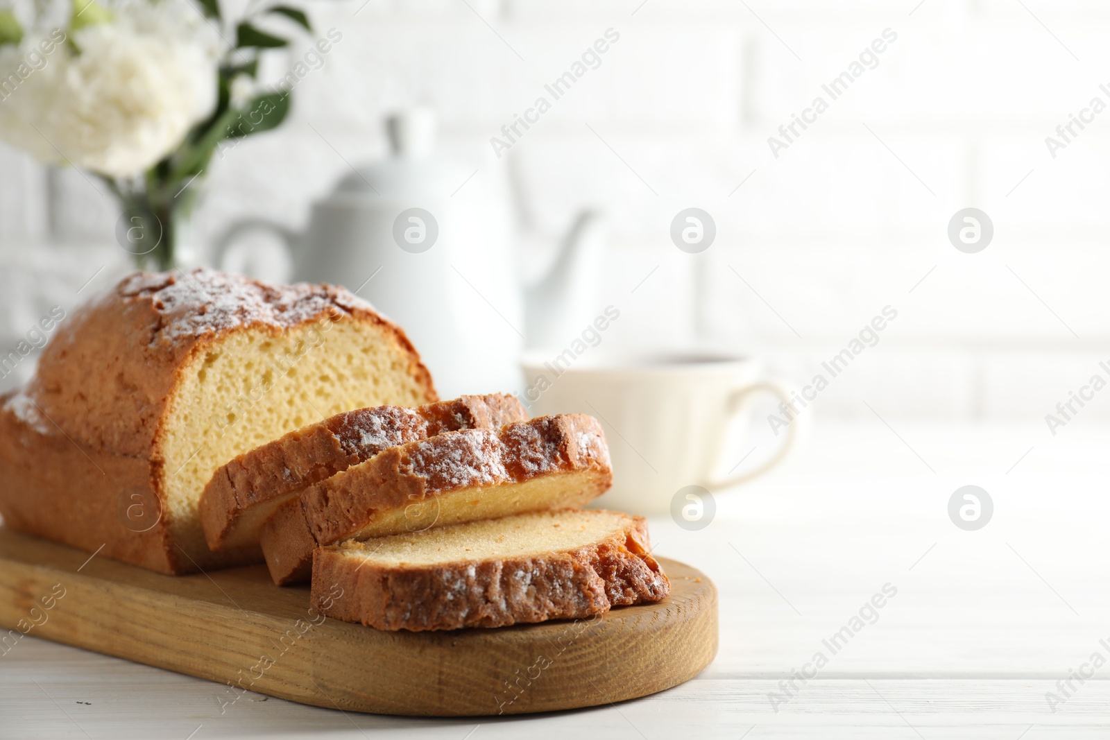 Photo of Freshly baked sponge cake on white wooden table, closeup. Space for text