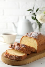 Photo of Freshly baked sponge cake on white wooden table, closeup