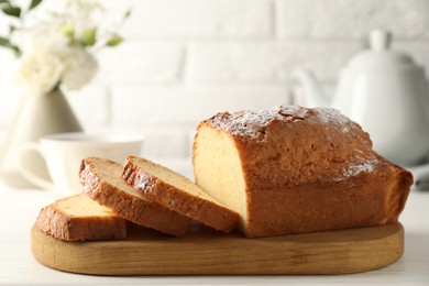 Photo of Freshly baked sponge cake on white wooden table, closeup