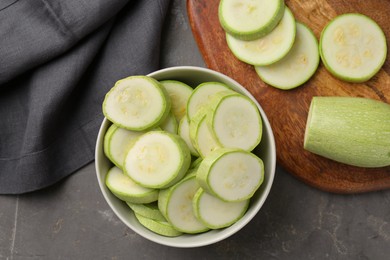 Photo of Fresh cut zucchinis on grey textured table, flat lay