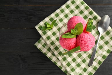 Photo of Scoops of tasty watermelon sorbet in glass dessert bowl with fresh fruit and spoon on black wooden table, flat lay. Space for text