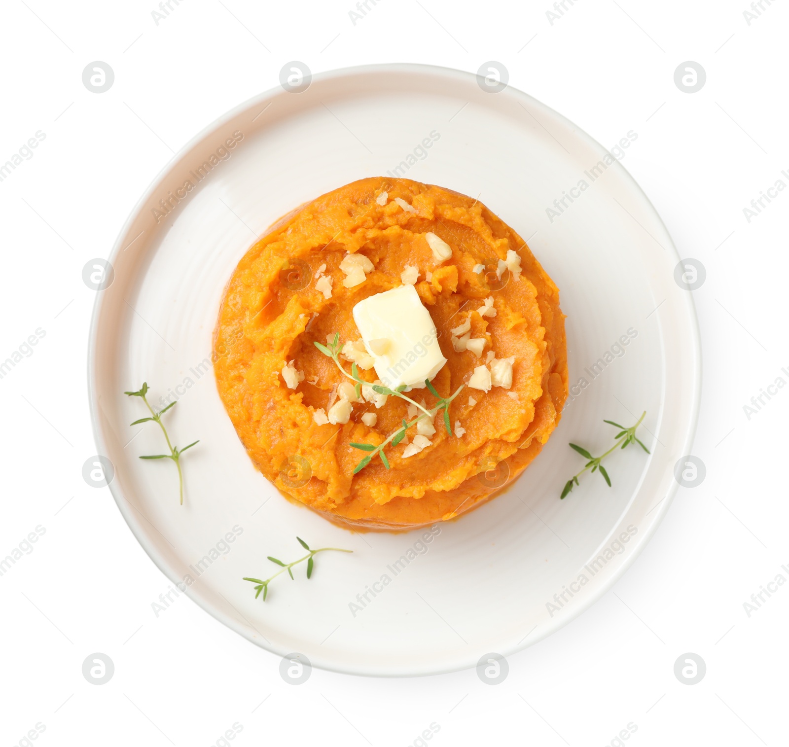 Photo of Plate with tasty mashed sweet potato, butter, thyme and walnuts isolated on white, top view