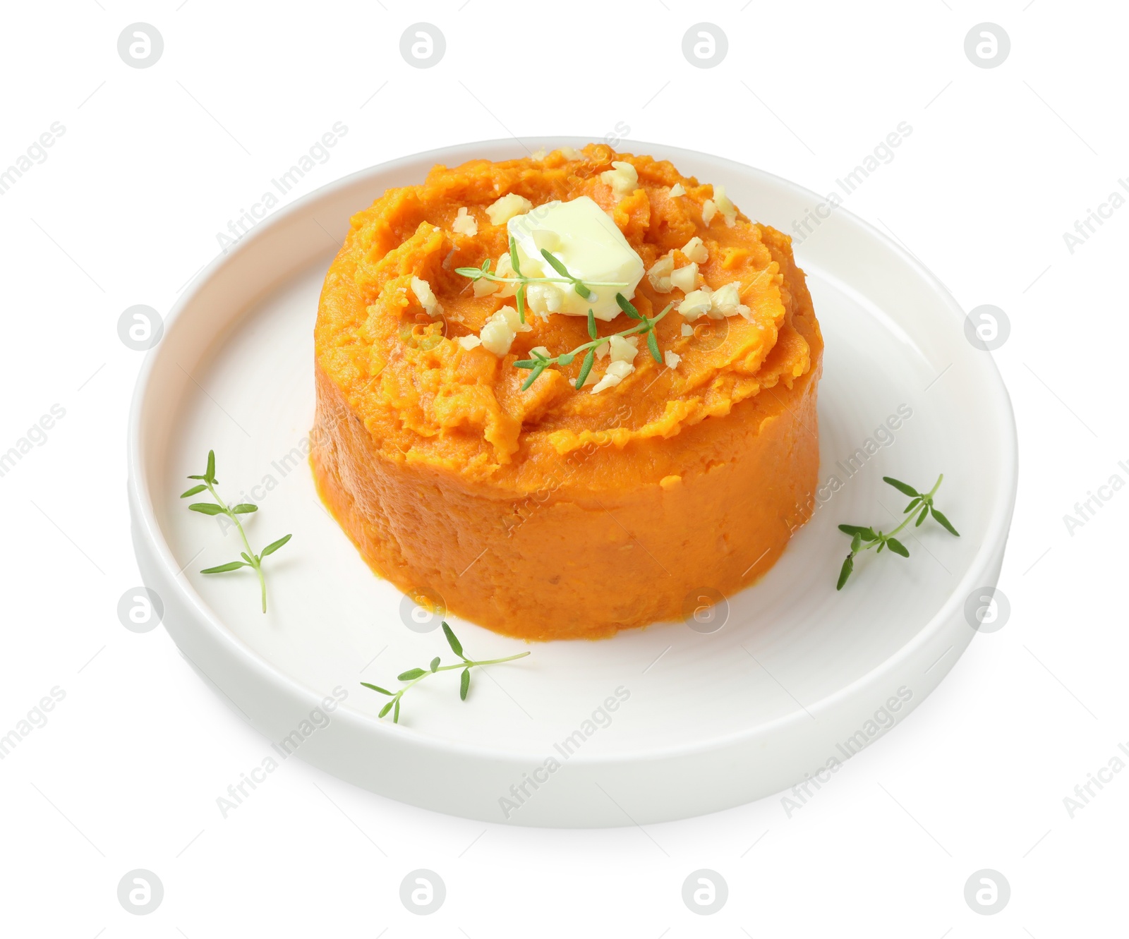 Photo of Plate with tasty mashed sweet potato, butter, thyme and walnuts isolated on white