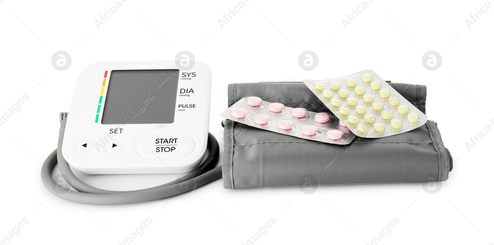 Photo of Blood pressure monitor and pills in blisters isolated on white