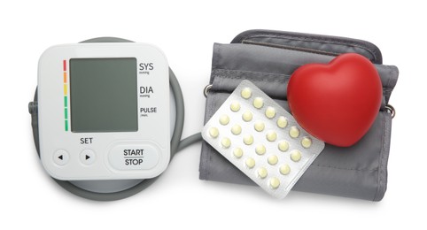 Photo of Blood pressure monitor, pills in blister and red decorative heart isolated on white, top view