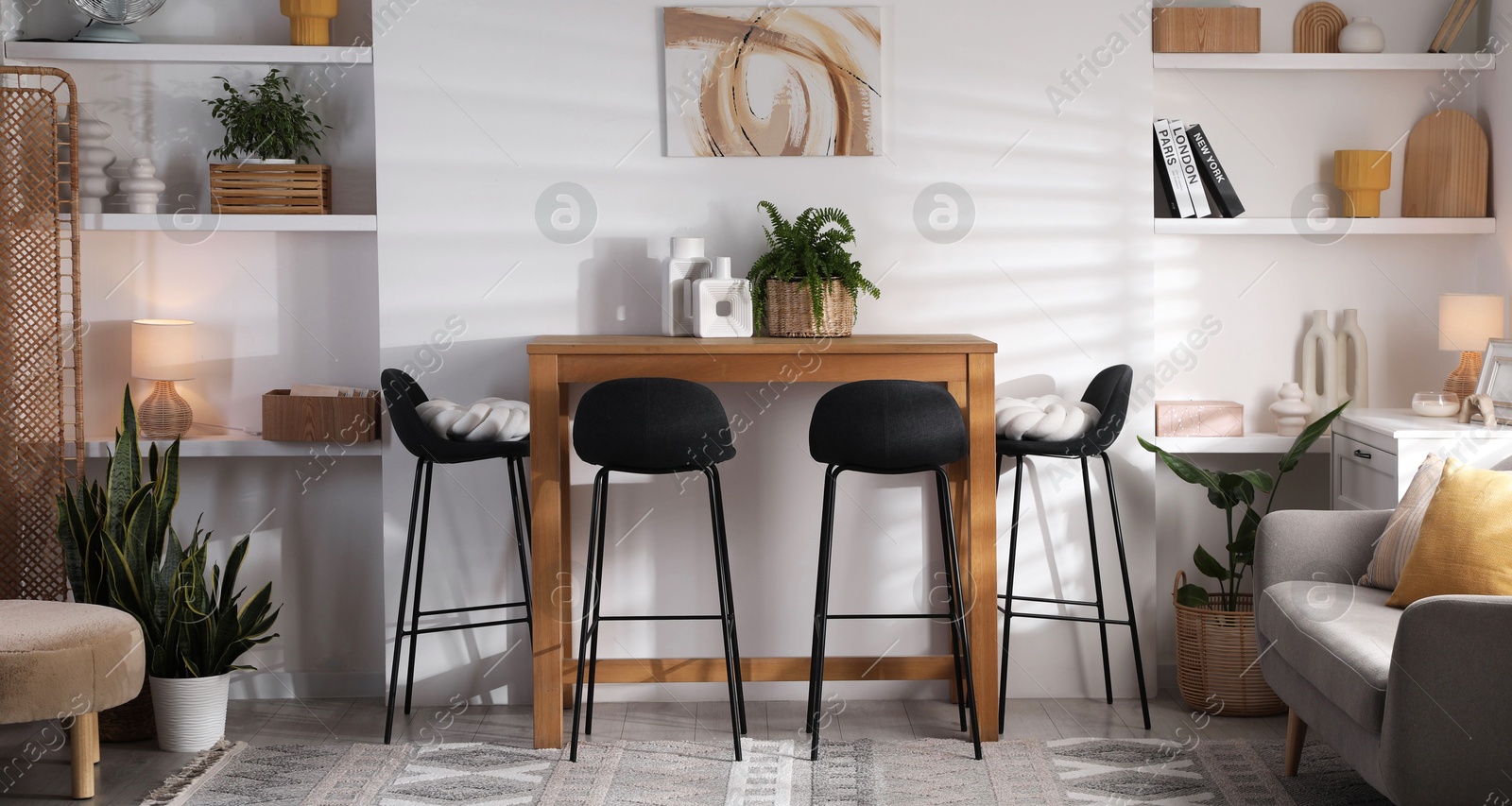 Photo of Bar stools near table in room. Interior design