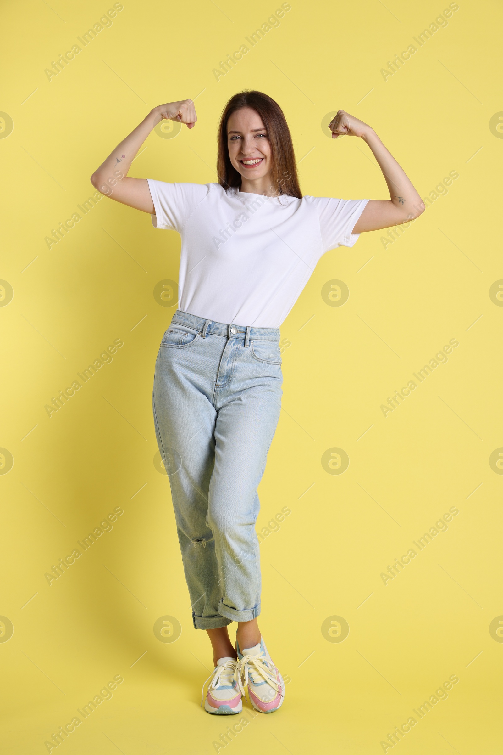 Photo of Portrait of happy winner on yellow background