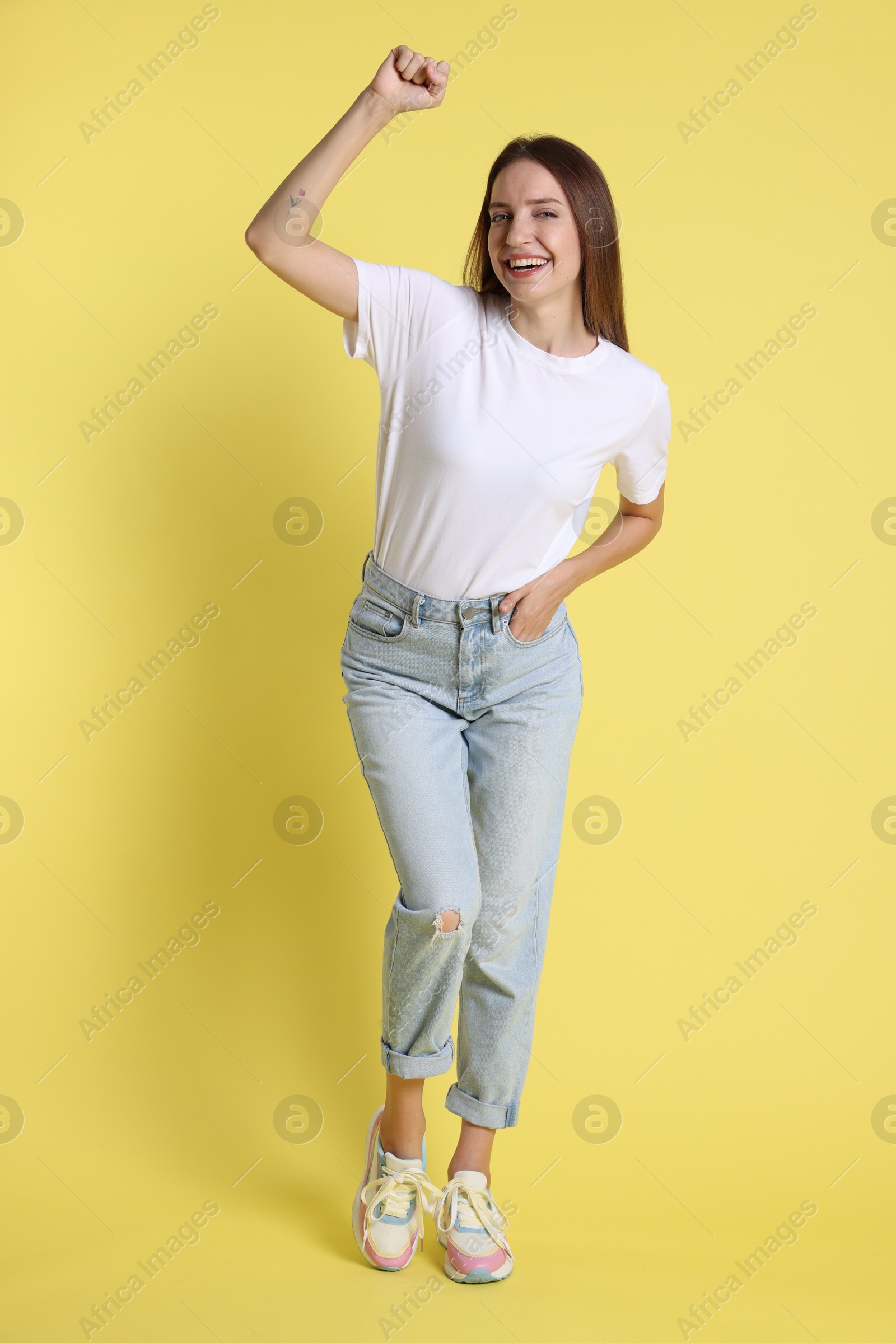 Photo of Portrait of happy winner on yellow background