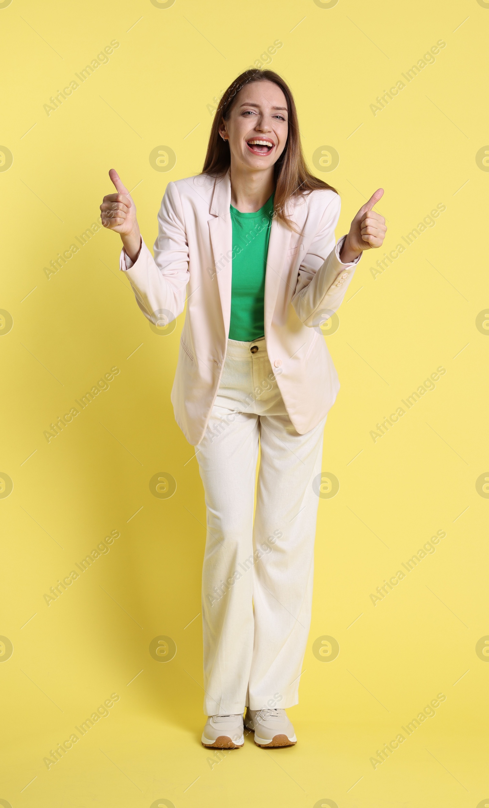 Photo of Happy winner showing thumbs up on yellow background