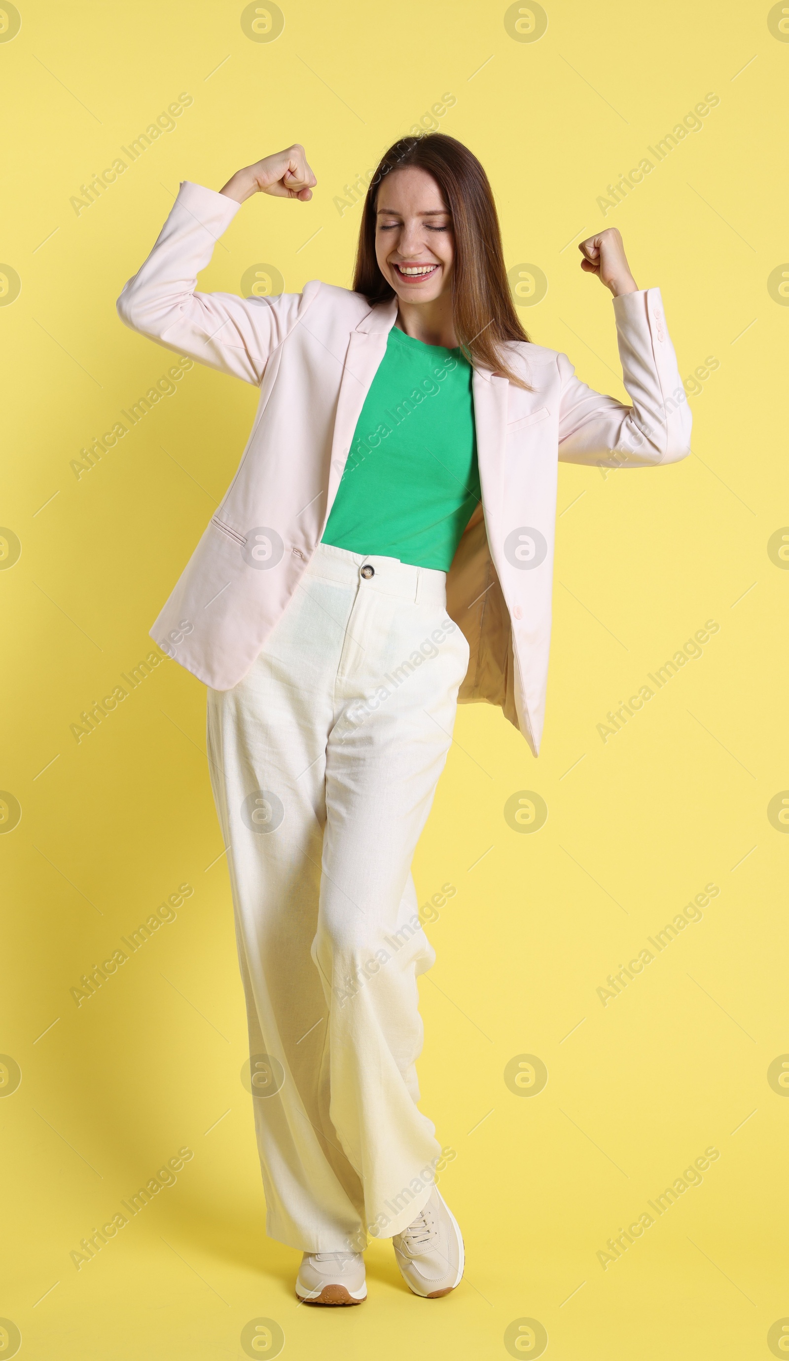 Photo of Portrait of happy winner on yellow background