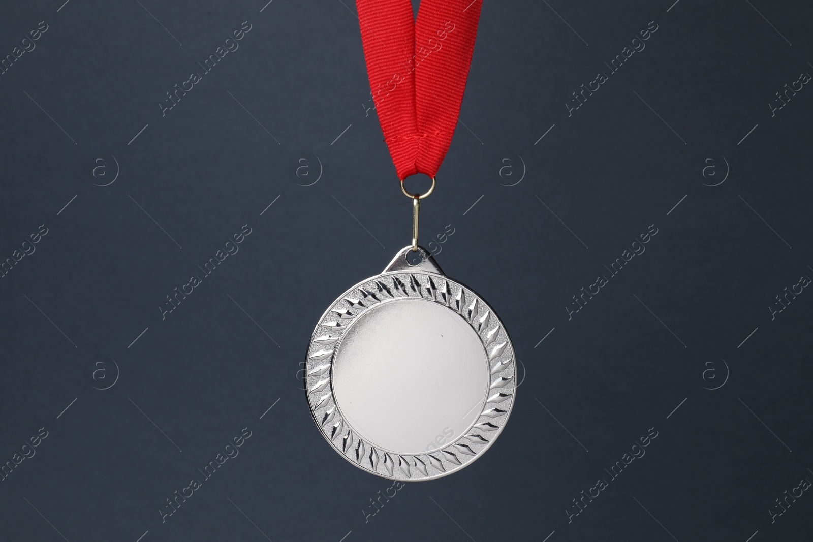 Photo of Silver medal with red ribbon on dark grey background