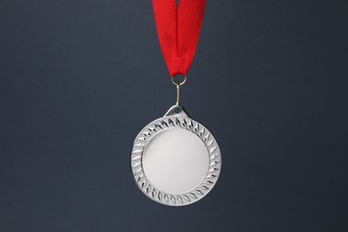 Photo of Silver medal with red ribbon on dark grey background