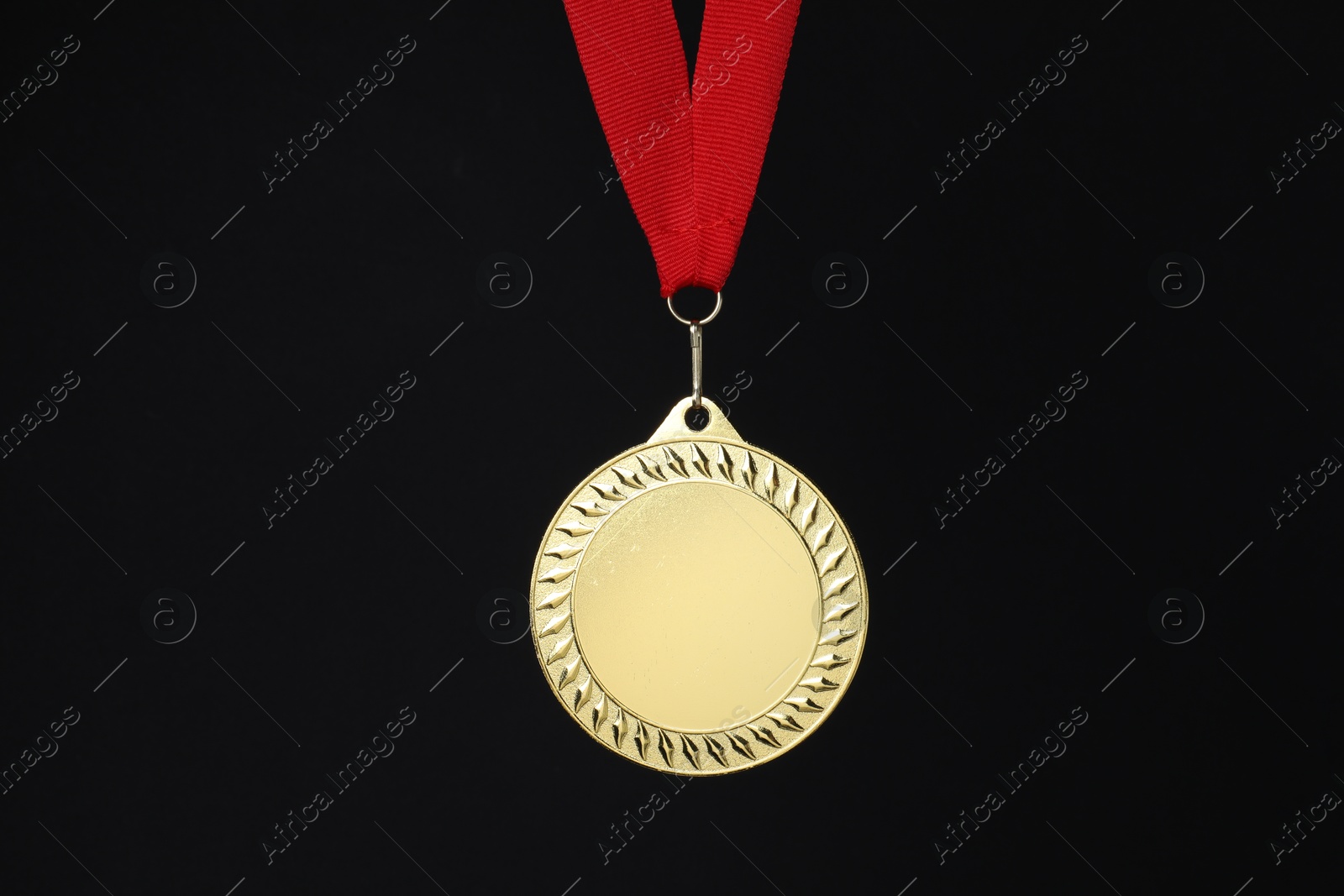 Photo of Golden medal with red ribbon on black background