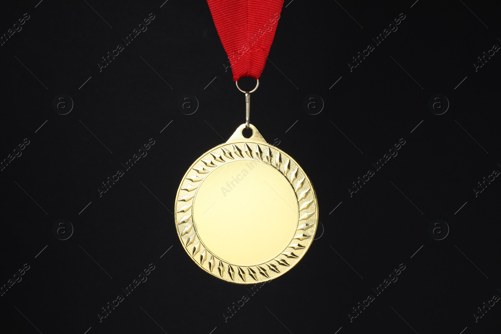 Photo of Golden medal with red ribbon on black background