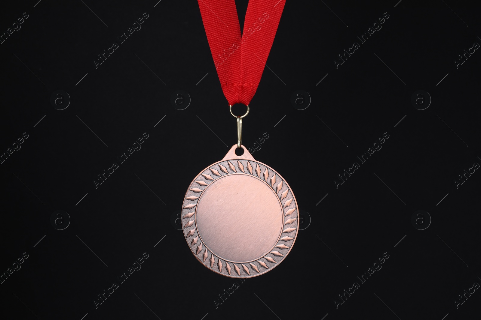 Photo of Bronze medal with red ribbon on black background