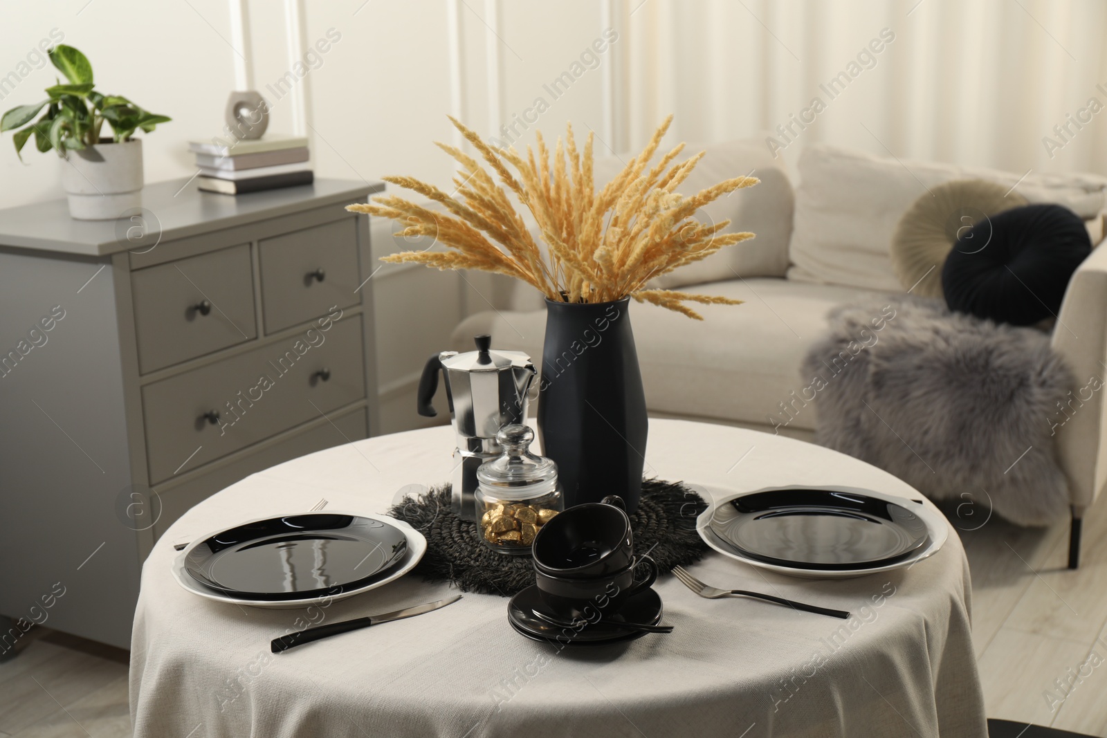 Photo of Stylish table setting with black dishware in dining room