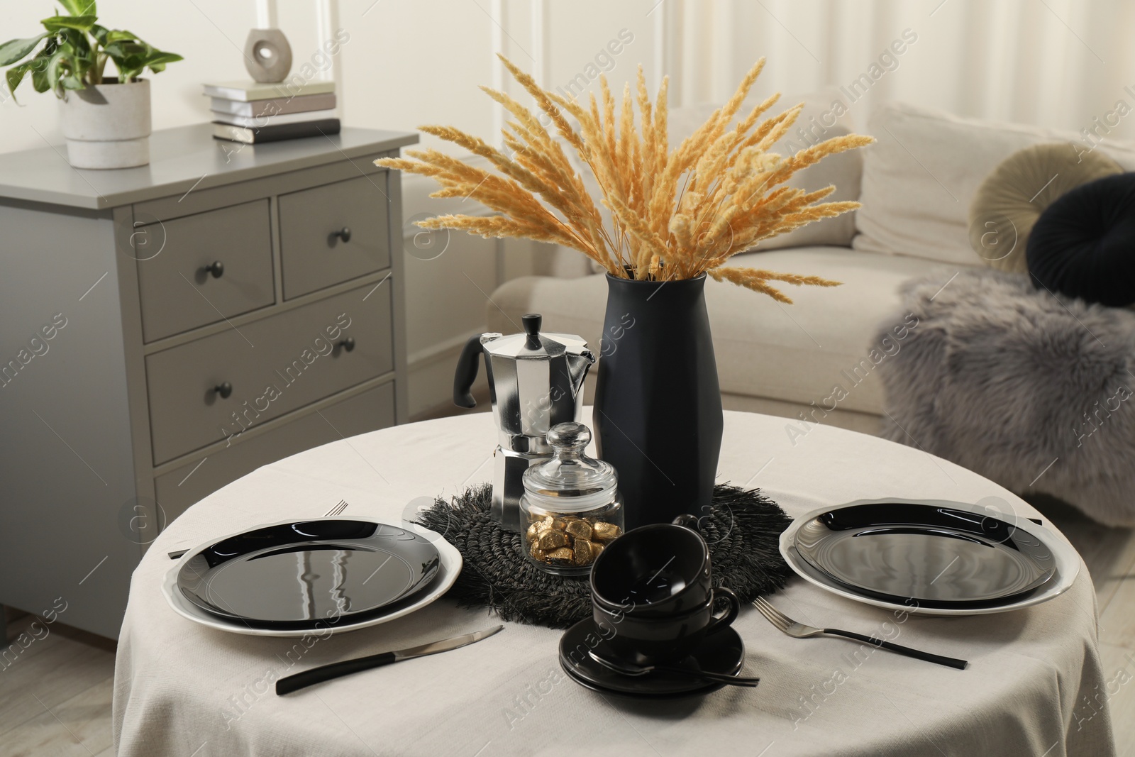 Photo of Stylish table setting with black dishware in dining room