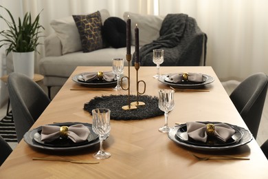 Photo of Stylish table setting with black dishware in dining room