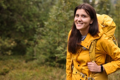 Photo of Young hiker with backpack in forest, space for text