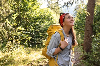 Young hiker with backpack enjoying time in forest