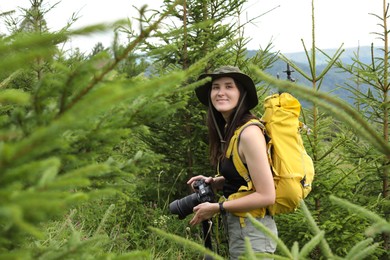 Photo of Young hiker with backpack and camera in forest