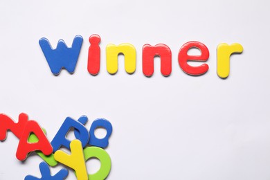 Photo of Word Winner made of magnetic letters on white background, flat lay