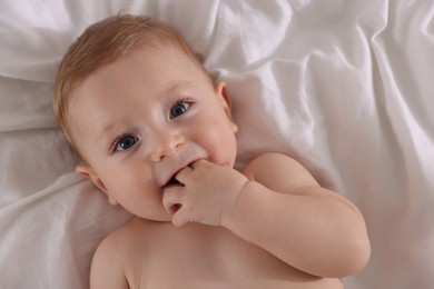 Photo of Cute little baby on bed, top view