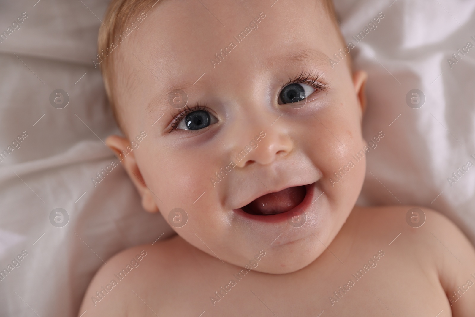 Photo of Cute little baby on bed, top view