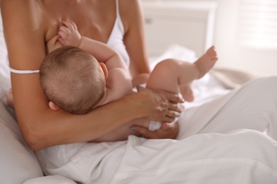 Mother breastfeeding her little baby indoors, closeup